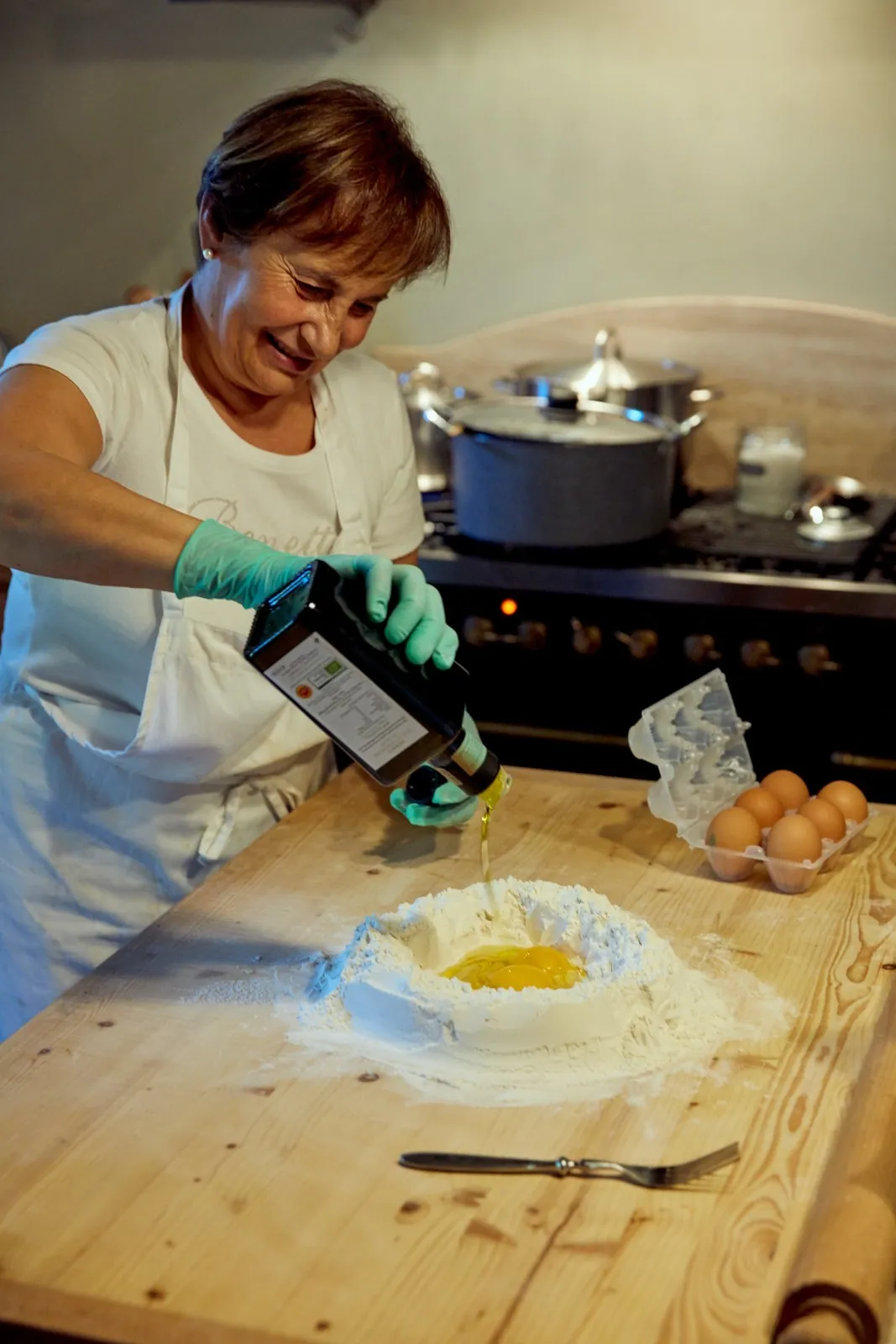 Olivenolje helles i en brønn av hvetemel og egg til fersk pasta.